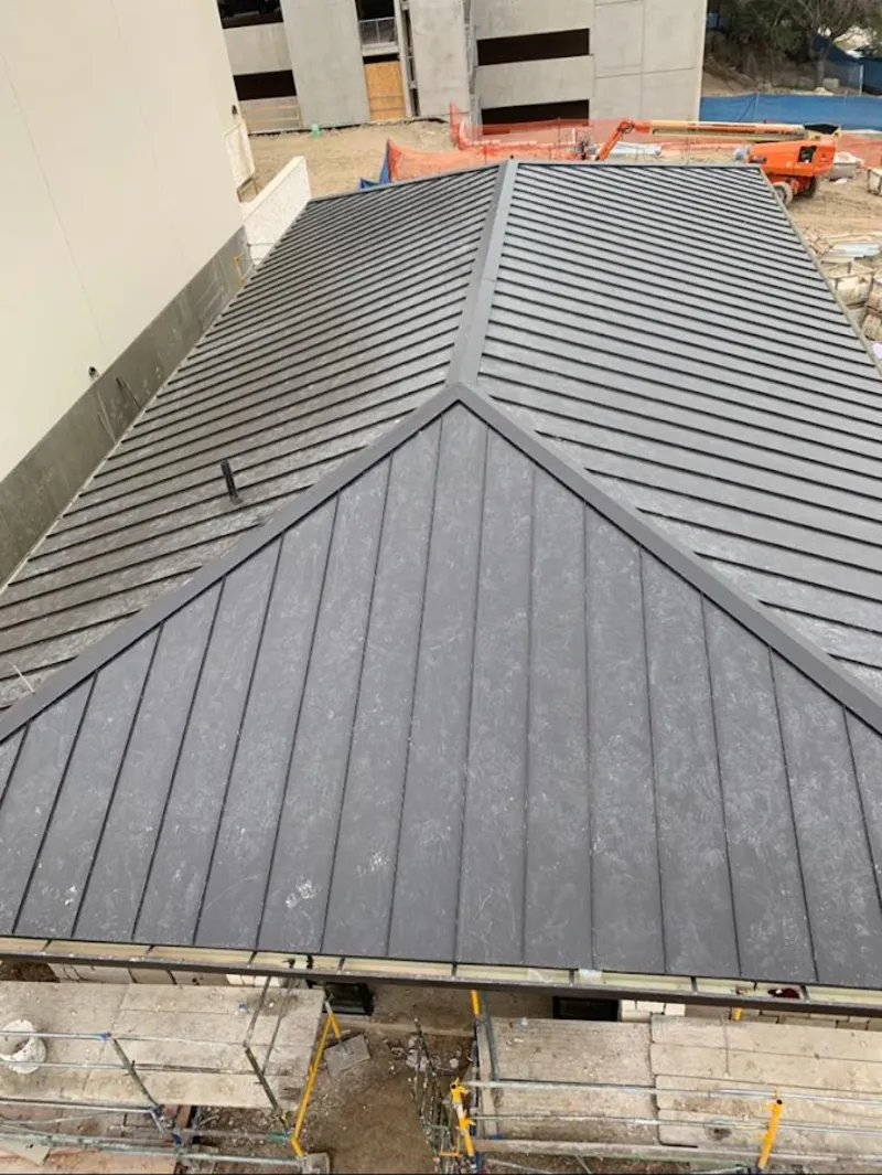 Commercial metal roof construction with crane equipment in Parole